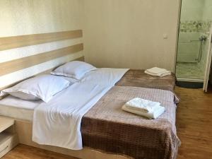 1 dormitorio con 1 cama con 2 toallas en Teo Guesthouse and Camping in Mestia, en Mestia