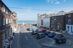 a city street with cars parked in a parking lot at Sea Front Walk in Broadstairs