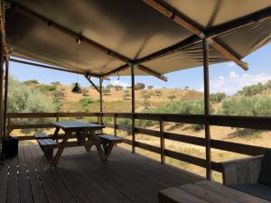 a wooden porch with a picnic table and views of a field at Cortijo Dos Santos in Valle de Abdalagís