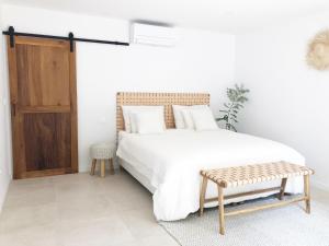 a bedroom with a white bed and a wooden cabinet at Luxury Family Beach Front Villa - SUNDAY BEACH HOUSE in Slatine
