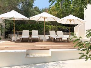 a group of chairs and umbrellas on a wooden deck at Luxury Family Beach Front Villa - SUNDAY BEACH HOUSE in Slatine