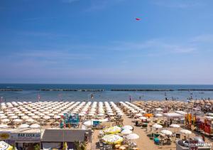 ベッラーリア・イジェア・マリーナにあるHotel Treviの多数の傘と水中の人々を持つ浜
