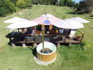 a food cart with umbrellas and chairs in a field at Glamping Abruzzo - The Yurt in Catignano
