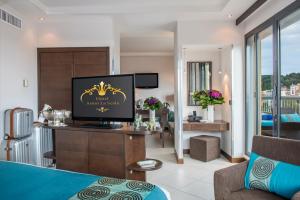 a living room with a tv in a hotel room at Hotel Aston La Scala in Nice