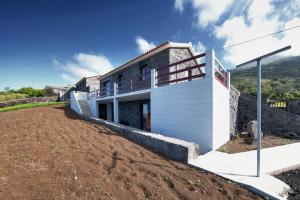 ein Haus auf einem Hügel mit einem unbefestigten Hof in der Unterkunft Melo's Place in Madalena