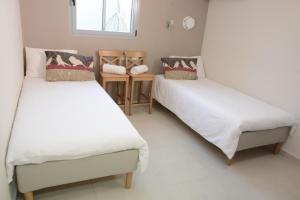 a room with two beds and a window at Luna BaNeguev in Yeroẖam