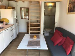 eine kleine Küche mit einem Sofa und einem Tisch in einem Zimmer in der Unterkunft Le Vénitien in Arles