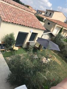 einen Hof mit einem Haus mit Sonnenschirm und Stühlen in der Unterkunft Le Vénitien in Arles