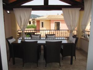 a dining room with a table and chairs on a balcony at La Casa delle Conchiglie in Villasimius