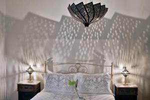 a bedroom with a white bed with two nightstands and a lamp at ALIA MANSION by K&K in Megalochori