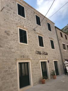 a stone building with windows and a sign on it at Villa Radić in Ston