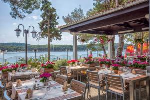 a restaurant with tables and chairs and a view of the water at Diana B&B in Mali Lošinj