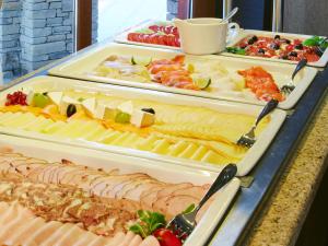 a buffet with several trays of different types of food at Domki Czarny Groń in Rzyki