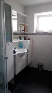 a white bathroom with a sink and a window at Wohnung für Monteure und Messebauer in Algermissen