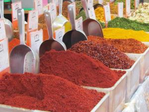 a display of spices in a market with spoons at Blue Sea Marble in Tel Aviv