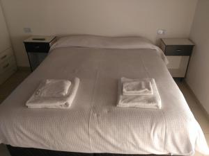 a bed with two white towels on top of it at Departamento Andino del Sol in San Juan