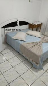 un letto su un pavimento piastrellato in una stanza di Hostel Fariafaz a Gaspar