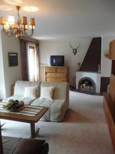 a living room with a white couch and a fireplace at 4 Elements Appartmenthaus Monarda in Flachau