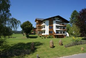 a large building on a green field with trees at Almenlandhof in Fladnitz an der Teichalm