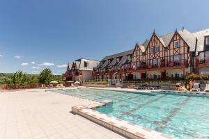 a large swimming pool in front of a building at Pierre & Vacances Premium Residence & Spa Houlgate in Houlgate