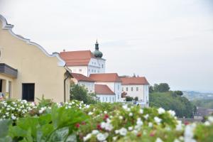 a group of white buildings with red roofs and flowers at Bastei Apartment Enns in Enns