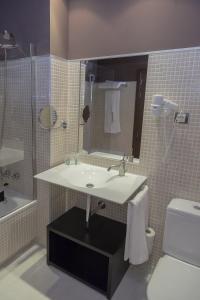 a bathroom with a sink and a toilet at Hotel Real Balneario Carlos III in Trillo