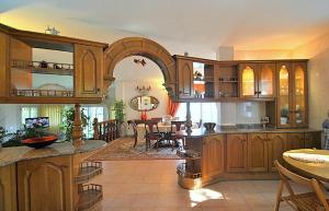 eine große Küche mit Holzschränken und ein Esszimmer in der Unterkunft Holiday villa in 10 min from Fuengirola beach with sea views pool BBQ parking WiFi aircon big garden in Mijas Costa