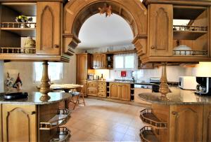 eine große Küche mit Holzschränken und einem Tisch in der Unterkunft Holiday villa in 10 min from Fuengirola beach with sea views pool BBQ parking WiFi aircon big garden in Mijas Costa