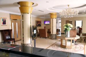 a lobby with columns and a table and a chandelier at Hotel Amaritsah in Brazzaville