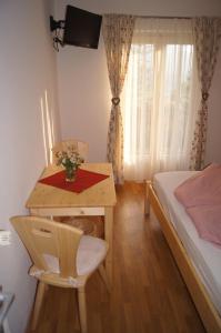 a small bedroom with a bed and a table and a desk at Schlaferhof - Urlaub am Bauernhof in Fresach