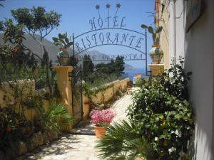 a garden with a gate with flowers and plants at Torre Bennistra in Scopello