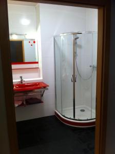 y baño con ducha y lavabo rojo. en Pension und Gästehaus Paffrath en Großbrembach