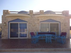 a patio with blue tables and chairs on a building at Light House in Marsa Alam City