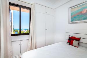 een slaapkamer met een wit bed en een raam bij WHome | Albufeira Suite & Beach Apartment in Albufeira