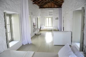 een witte kamer met 2 bedden en een bank bij Ecloge, Hydra Island in Hydra