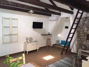 a living room with a television and a ladder at Old Town Apartment in Krk