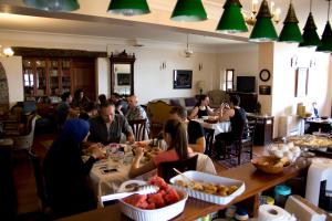 a group of people sitting at tables in a restaurant at Altın Çeşmeli Konak in Altınoluk