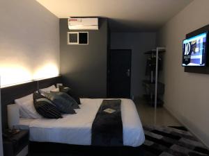 a bedroom with a bed with pillows and a television at Hotel Doral Inn in Ibagué