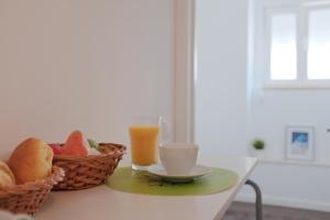 einen Tisch mit einem Korb Brot und einem Glas Orangensaft in der Unterkunft Like-home Casa Prazeres in Lissabon