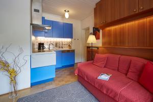 a living room with a red couch and blue cabinets at Villa Christina in San Candido