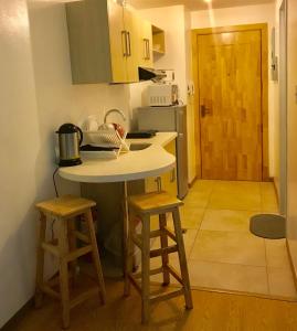 a small kitchen with a counter and two stools at Cedar Peak Condominium in Baguio
