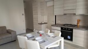 a kitchen with a white table and white chairs at CA' VEGIA in Gravedona