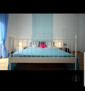 een slaapkamer met een bed met blauwe lakens en kussens bij Central Hostel Milano in Milaan