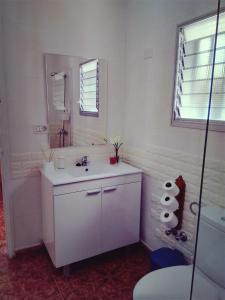 Un baño blanco con lavabo y espejo. en Casa Belinda, en San Nicolás