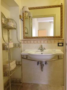 een badkamer met een wastafel en een spiegel bij La Casina del Borgo in Abbadia San Salvatore