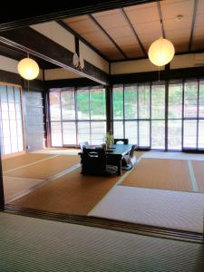 Habitación grande con mesa y algunas ventanas. en Kumano Kodo Nagano Guesthouse en Tanabe