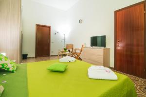 B&B U PRUFISSURI في أفولا: غرفة نوم بسرير اخضر عليها مناشف