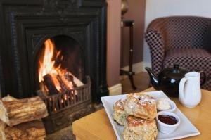 a plate of pastries on a table with a fireplace at Island View Roundstoneselfcatering in Roundstone