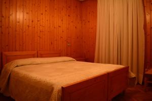 a bedroom with a bed in a wooden wall at Albergo - B&B Alpina in Valdidentro