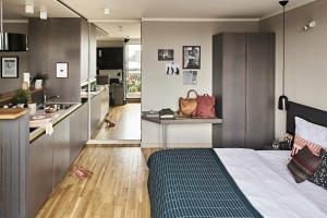 a bedroom with a bed and a kitchen at Bold Hotel München Zentrum in Munich